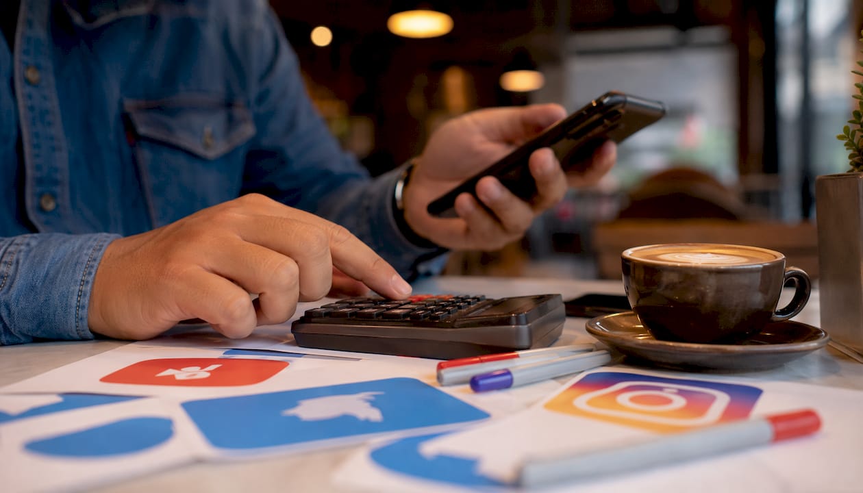 Hands calculating social media advertising costs